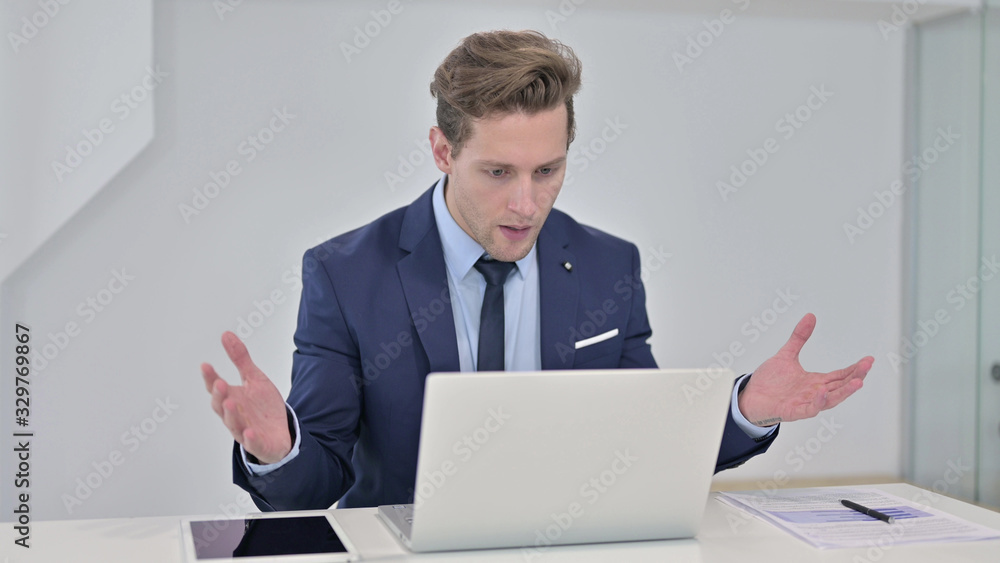 Shocked Young Businessman Reacting to Failure on Laptop Shocked Young Businessman Reacting to Failure on Laptop