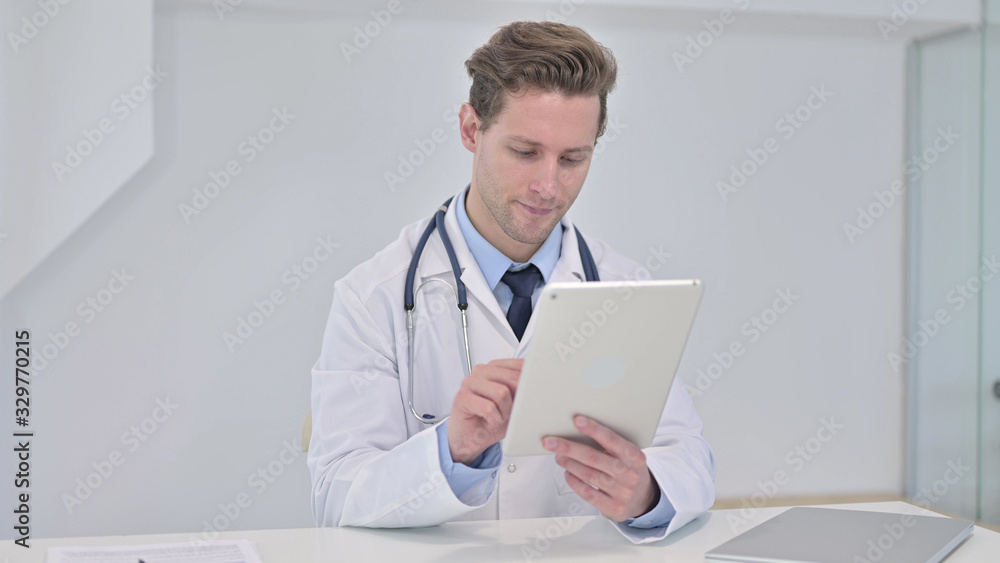 Young Male Doctor using Tablet in Modern Office