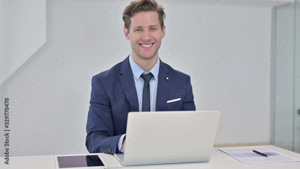 Young Businessman Looking at Camera and Smiling Young Businessman Looking at Camera and Smiling