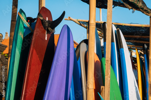 Set of different color surf boards in a stack by ocean.Bali.Indonesia. Surf boards on sandy beach for rent. Surf lessons on Weligama beach, Sri Lanka. photo