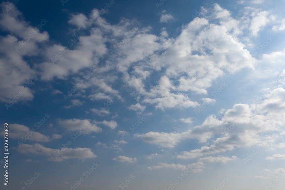 Fluffy white clouds on blue sky background.