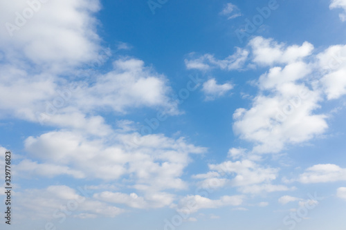 Fluffy white clouds on blue sky background.