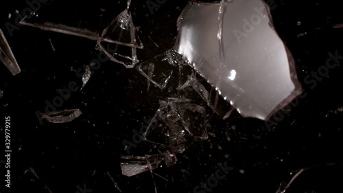 Shooting glass shatters in slow motion on black background