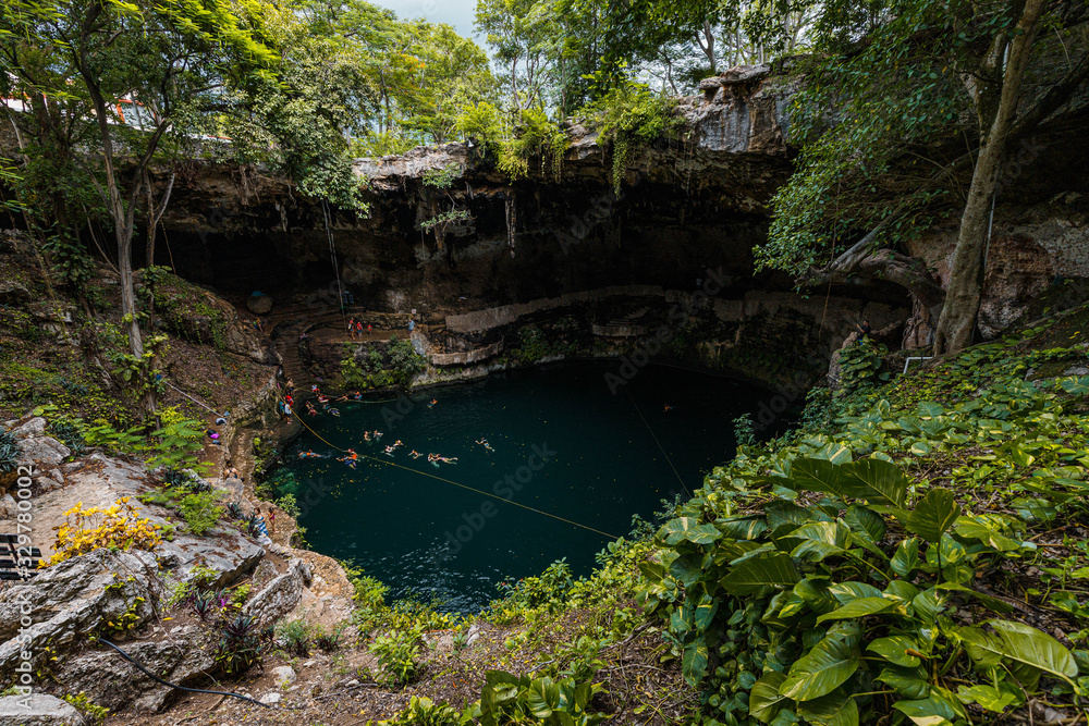 View into the crystal clear and blue water of a typical Mexican cenot (Zaci Cenote) in Valladolid near Cancun (Yucatan Peninsula, Mexico, America) View into the crystal clear and blue water of a typical Mexican cenot (Zaci Cenote) in Valladolid near Cancun (Yucatan Peninsula, Mexico, America)