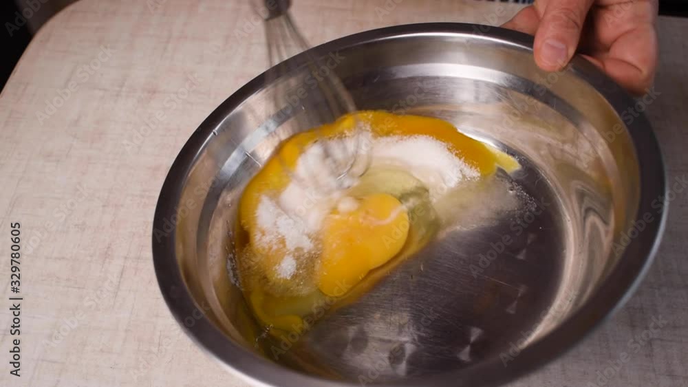Whisking together eggs and sugar in bowl. Whisking together eggs and sugar in bowl.