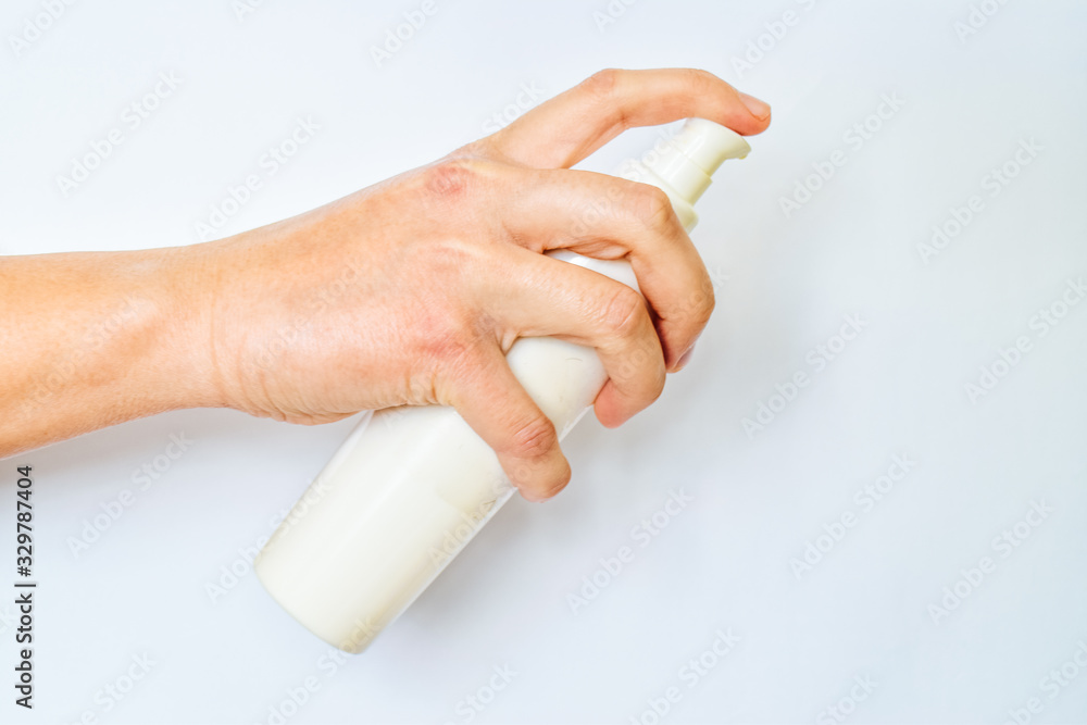 Woman hand holds bottle of soft cream against to white background. Skin care concept. Woman hand holds bottle of soft cream against to white background. Skin care concept.