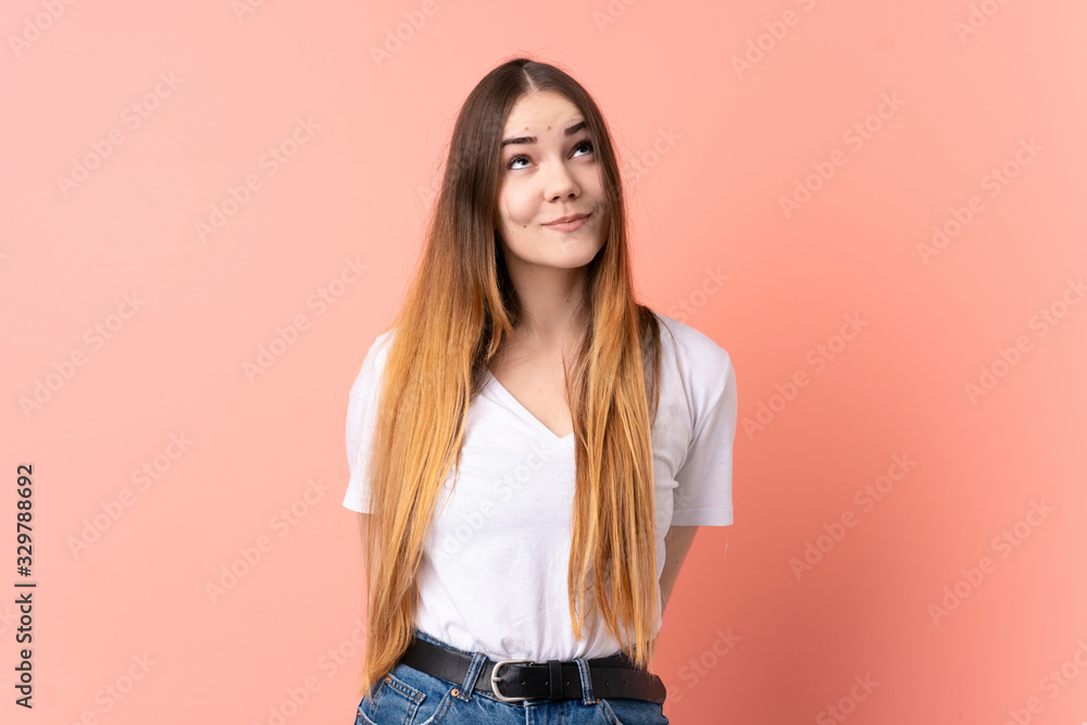 Young caucasian woman isolated on pink background and looking up Young caucasian woman isolated on pink background and looking up