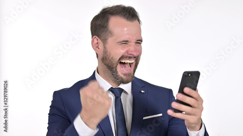 Portrait of Cheerful Young Businessman Celebrating on Smartphone, White Background