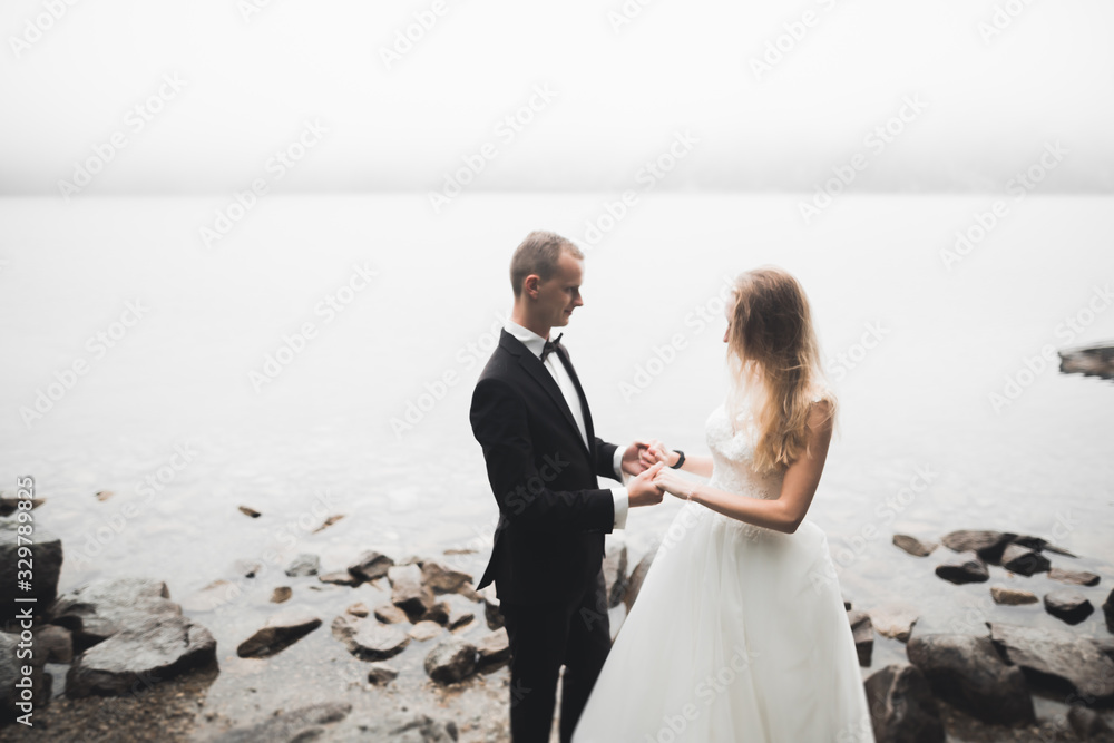Happy wedding couple staying over beautiful landscape Happy wedding couple staying over beautiful landscape