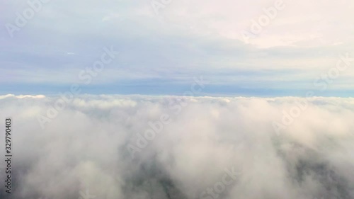 Aerial clouds flying sky in motion. Aerial view white clouds in blue sky during sunrise or sunset. Aerial top view cloudscape. Texture of clouds. Panoramic view. Clouds in motion. Fast playback	