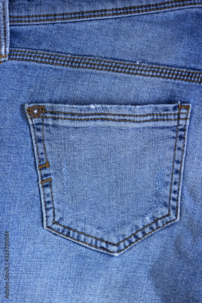 Back pocket of female blue jeans, background. Close-up, clothes Back pocket of female blue jeans, background. Close-up, clothes