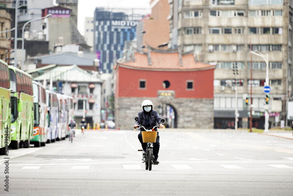 A Chinese man, wearing a face mask to protect himself from the novel coronavirus 2019-nCoV or COVID-19 is riding a scooter in Taipei, Taiwan.