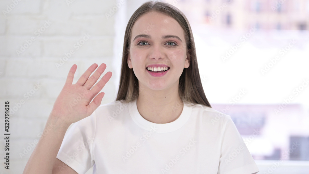 Portrait of Young Woman Waving at Camera