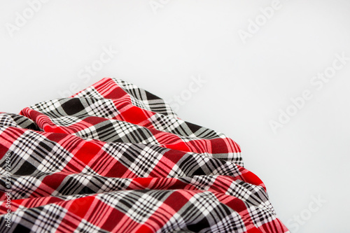 Red checkered fabric. Black and red checkered Scottish model. Textiles from plaid, tablecloths, clothes, shirts, dresses.