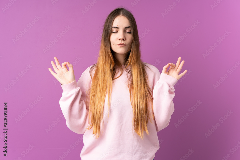 Young caucasian woman isolated on purple background in zen pose Young caucasian woman isolated on purple background in zen pose