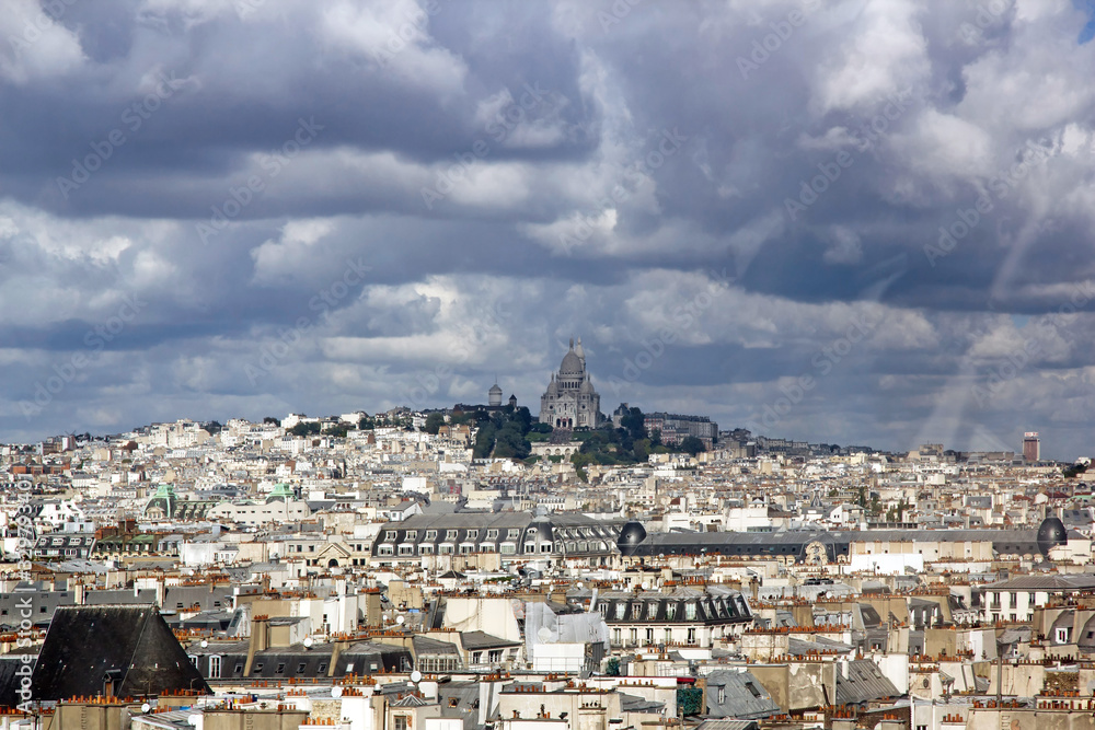 Fototapeta premium Les toits de Paris sous un ciel d'orage . Au loin le Sacré Coeur (Paris France)