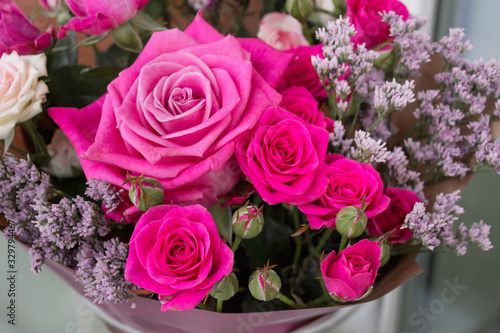Gift bouquet with pink roses and decorative plants.