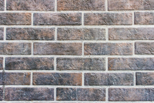 Texture of brick wall made of dark brown black bricks.