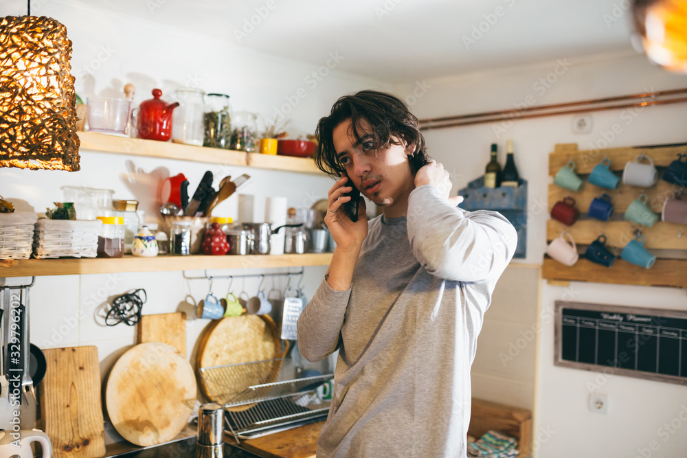 man using mobile phone in kitchen. morning scene