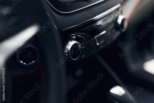 Leather car interior. Modern car illuminated dashboard. Luxurious car instrument cluster. Close up shot of automobile instrument panel. Modern car interior dashboard and steering wheel