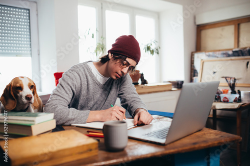 young man freelance working from home photo