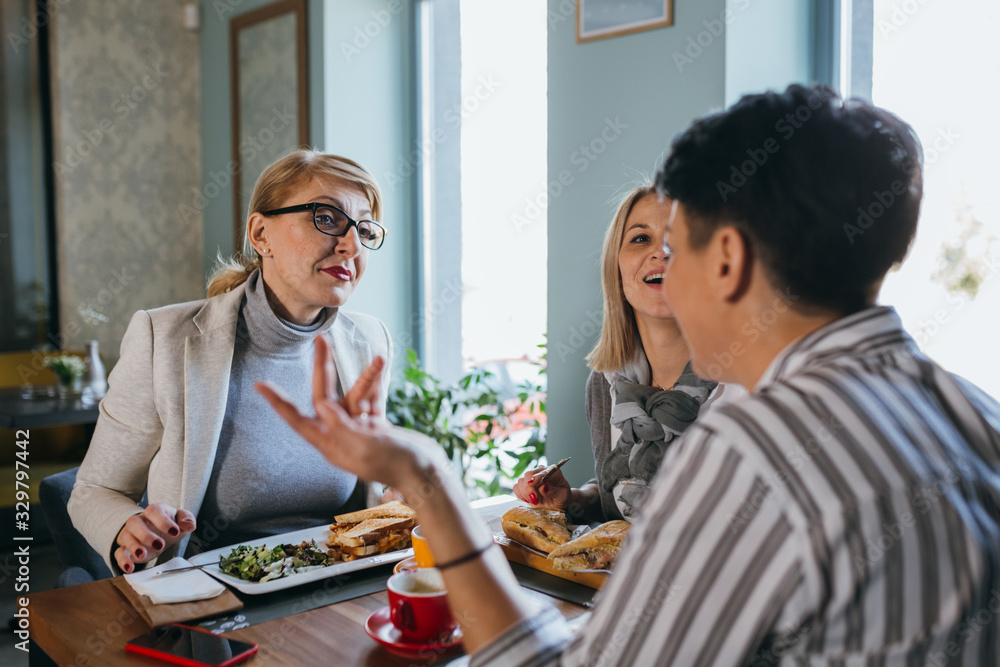 woman friends on breakfast or lunch in restaurant talking
