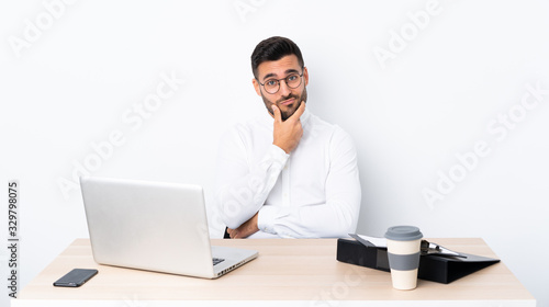 Young businessman in a workplace thinking