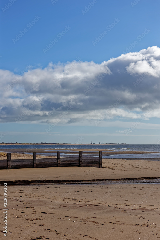 A Wooden Groyne near to a River outlet on the gently shelving sand beach of Monifieth on the East Coast of Scotland, near Dundee.