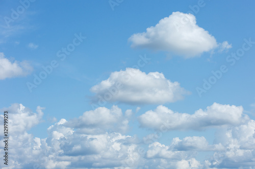 A large cluster of white Cumulus clouds in a blue sky. © broniktav