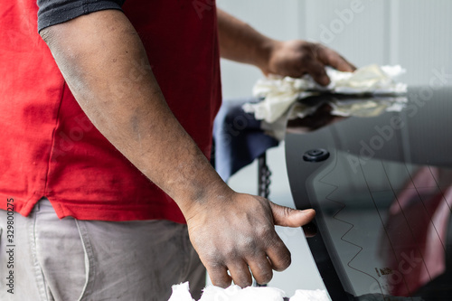 Car repair service, Afro American man working on glass replacement. Windshield insurance, safety and driving concept. Automotive industry.