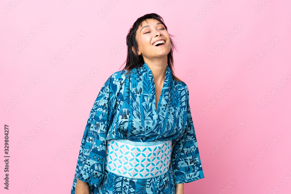 Young woman wearing kimono over isolated blue background laughing Young woman wearing kimono over isolated blue background laughing