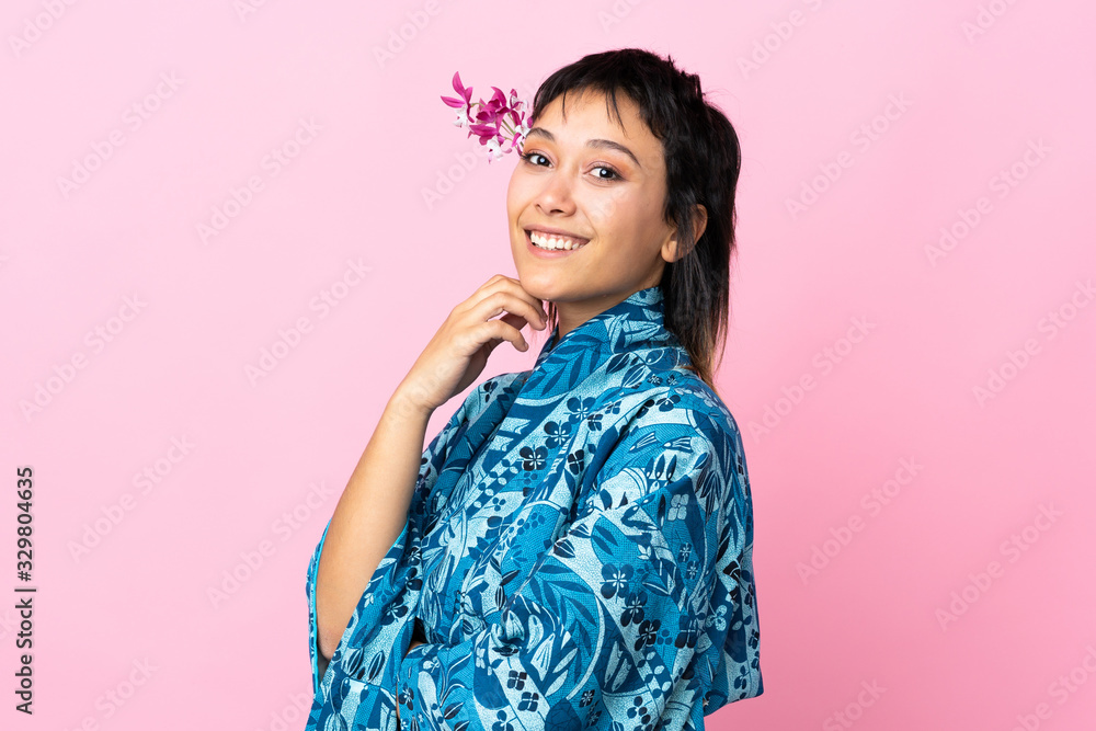 Young woman wearing kimono over isolated pink background Young woman wearing kimono over isolated pink background