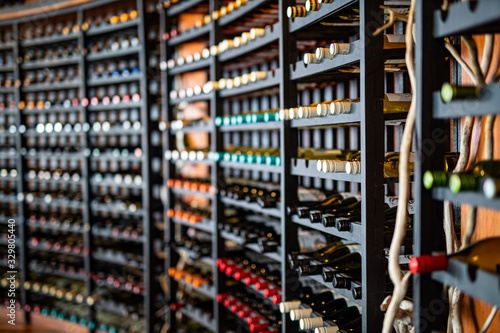 Resting wine bottles stacked on wooden racks in cellar 