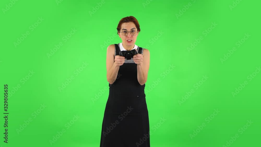 Funny girl in glasses is playing video game using wireless controller and losing. Green screen Funny girl in glasses is playing video game using wireless controller and losing. Green screen
