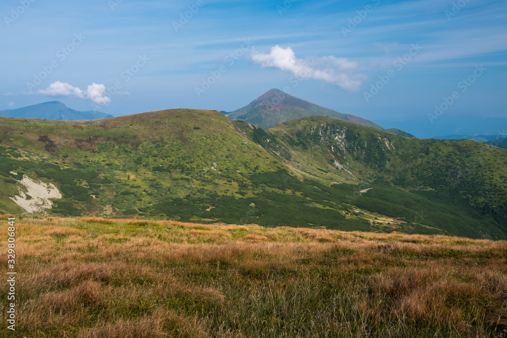 Summer landscape in mountains and the dark blue sky with clouds