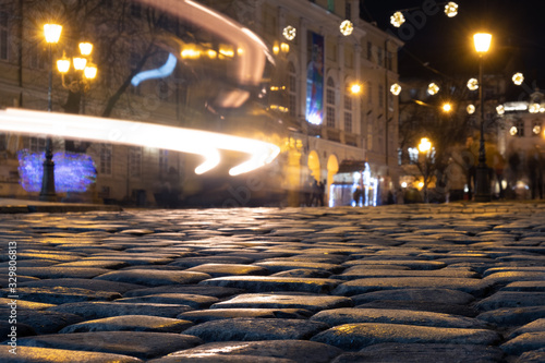 Cobble stones old european street with night city lights.