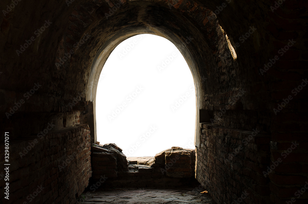 The ancient tunnel, aged construction of historical fortress isolated on white background; Dark inside. Light at the end of tunnel.