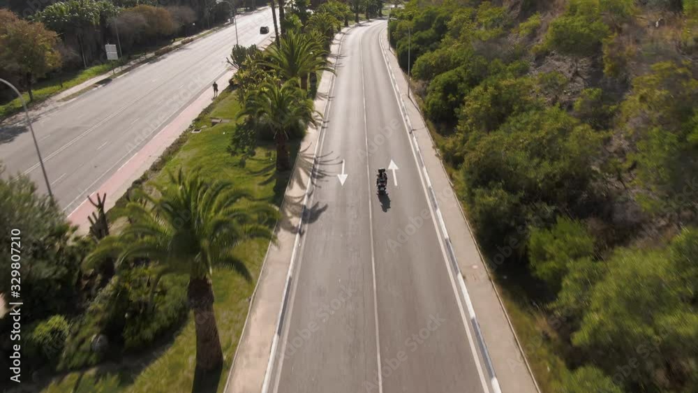 Rising drone shot behind a couple riding a motorbike in Marbella Spain Rising drone shot behind a couple riding a motorbike in Marbella Spain