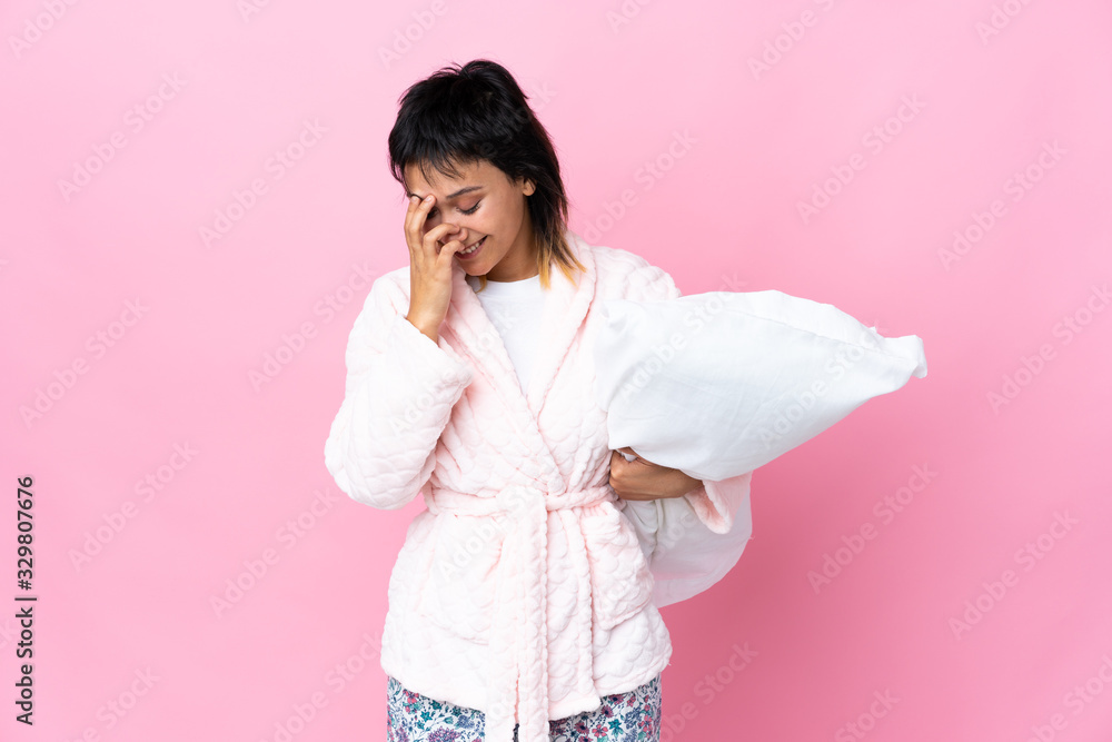 Young Uruguayan woman in pajamas over isolated pink background laughing Young Uruguayan woman in pajamas over isolated pink background laughing