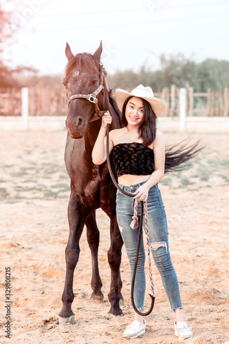 Beautiful Asia girl taking care of her horse with love and caring.