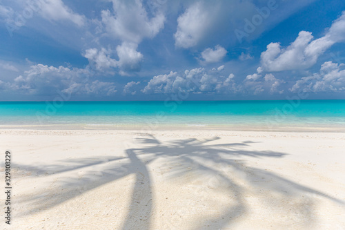 Summer travel vacation landscape with palm tree shadow on white sand close to blue sea. Idyllic tropical pattern on beach. Exotic nature landscape