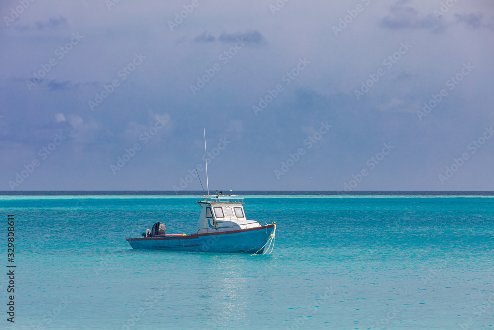 Small fishing boat and ship in front of beautiful seascape scenery and blue sky at Maldives island. Traditional and way of life concept. Small fishing boat and ship in front of beautiful seascape scenery and blue sky at Maldives island. Traditional and way of life concept.