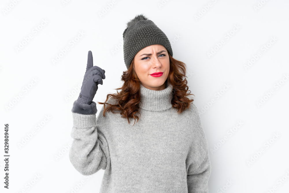 Young Russian woman with winter hat over isolated white background pointing with the index finger a great idea Young Russian woman with winter hat over isolated white background pointing with the index finger a great idea