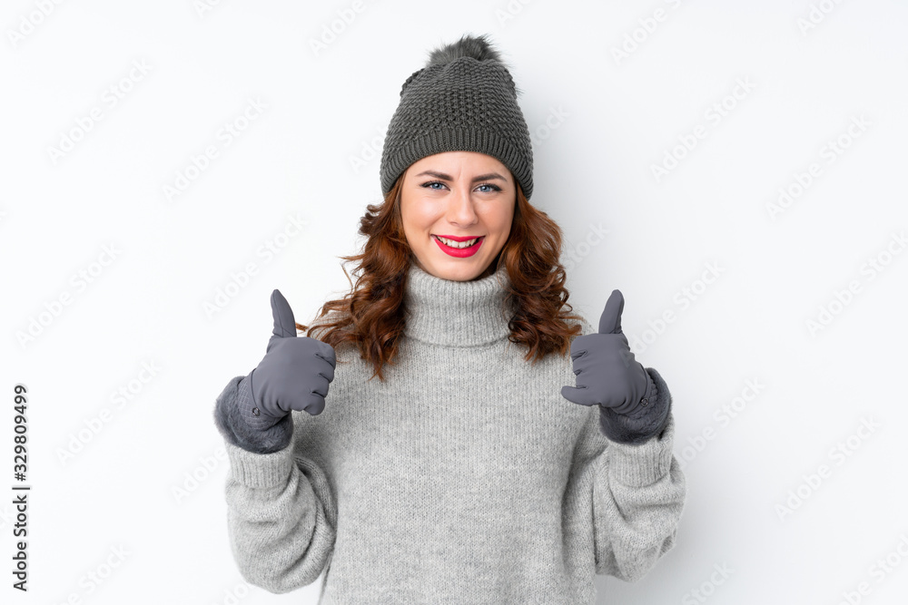 Young Russian woman with winter hat over isolated white background giving a thumbs up gesture Young Russian woman with winter hat over isolated white background giving a thumbs up gesture