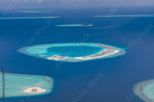 Luxury resort or hotel from aerial view. Maldives island landscape and seascape, amazing blue sea and tropical island with lagoon and coral reef