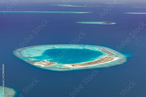 Luxury resort or hotel from aerial view. Maldives island landscape and seascape, amazing blue sea and tropical island with lagoon and coral reef