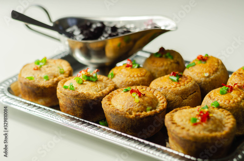 Traditional English pork pies with cranberry sauce on a silver tray