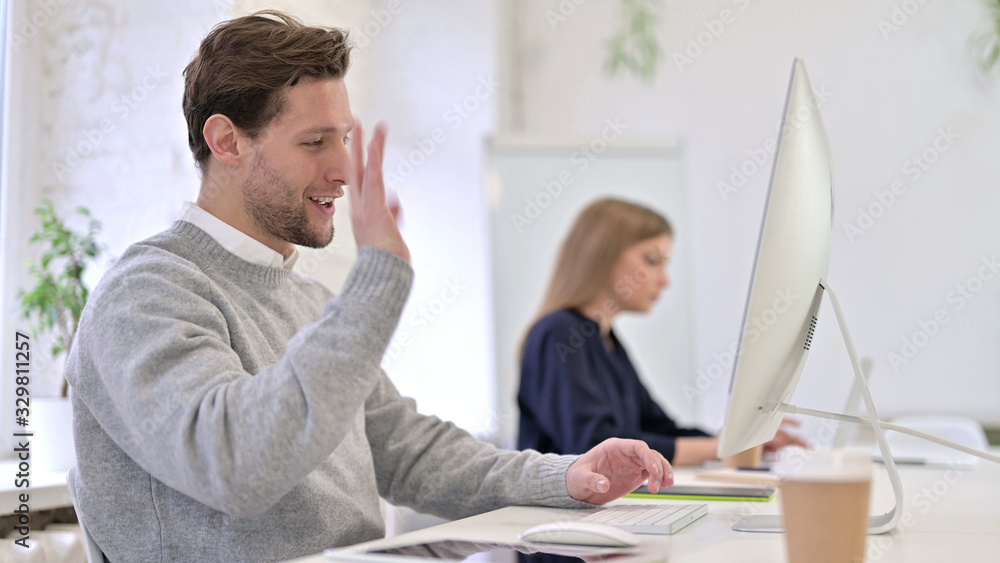 Obraz premium Cheerful Man doing Video Chat on Desktop