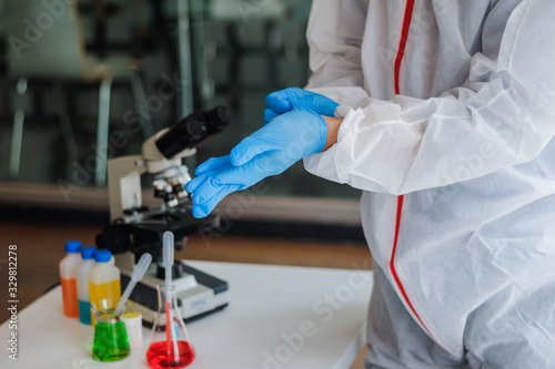 Medical scientists are wearing coronavirus protective clothing and rubber gloves before entering the lab for examination of coronavirus. covid-19 and research for a vaccine against coronavirus covid19