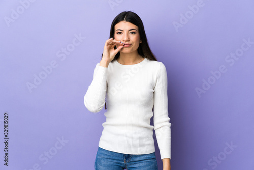 Young brunette woman over isolated purple background showing a sign of silence gesture